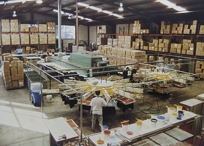 Photo of our Rosebery based screen printing factory  in the 90s, in the foreground, 2 x 10 colour automatic screen print machines in operation
